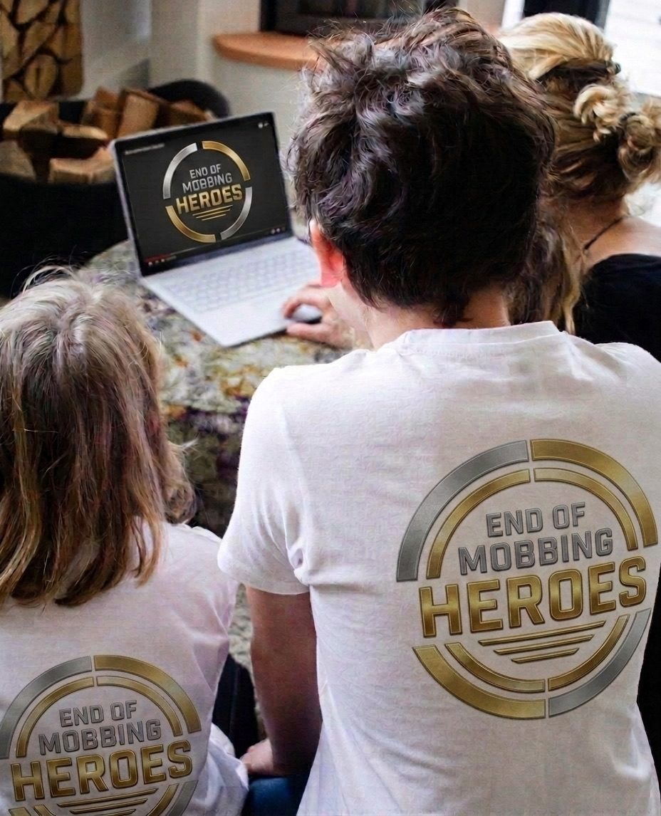 Familie schaut gemeinsam die EOM-Lehrvideos am Laptop, die Kinder tragen Helden-Shirts